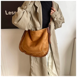 Detail of vintage brown suede tote bag with white contrast stitching and woven edge