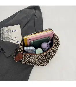 Top view of leopard print tote bag showing large interior capacity with a tablet and books