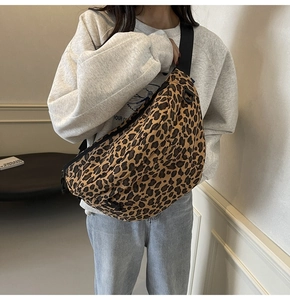 Detail of trendy leopard print canvas chest bag with adjustable black strap on a model