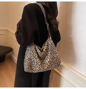 Detail of leopard print tote bag showing wide shoulder strap and leather reinforcement