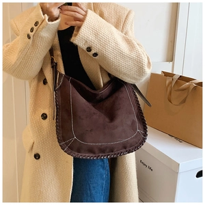 Detail of retro matte brown suede tote bag featuring contrast stitching and woven edges