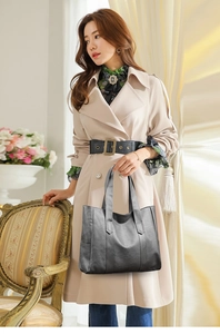 Detail of a large dark grey PU leather tote bag shown with a stylish beige trench coat