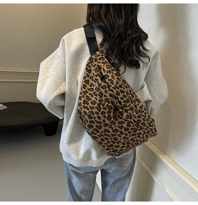 Leopard print crossbody crescent bag with adjustable wide strap shown on model back