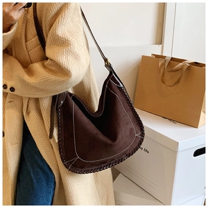 Detail of vintage brown suede tote bag with white contrast stitching and woven edges
