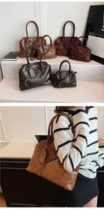Detailed close-up of retro leather tote bags in brown and burgundy with metal buckle