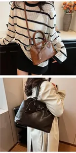 Detail view of vintage leather tote bags in brown and dark coffee with metallic buckles