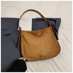 Detail of retro brown suede tote bag with white U-shaped stitching and leather weave