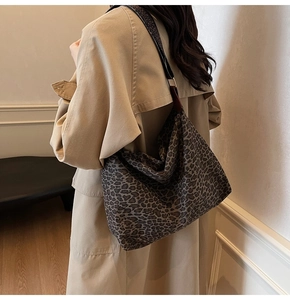 Detail view of large leopard print tote bag styled with a stylish khaki trench coat