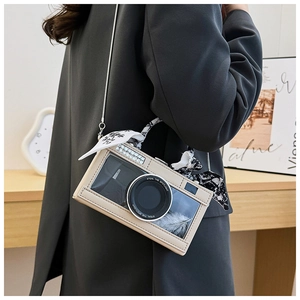 Detail of camera-shaped crossbody bag with decorative feathers and floral scarf handle