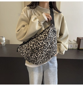 Detailed view of large leopard print crossbody bag worn on chest for casual style
