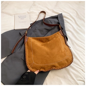 Close-up of brown matte suede tote bag with decorative contrast stitching and thick woven edges
