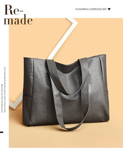 Detail view of large dark grey PU leather tote bag with side pocket and premium texture