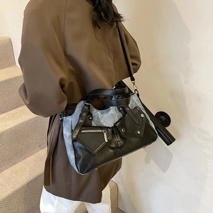 Retro patchwork tote bag in blue denim and black faux leather with metal rivet details