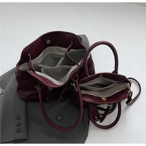 Interior structure of burgundy tote bag with main compartment and zipper pockets