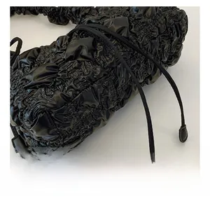 Détail de la texture matelassée noire avec coutures précises et cordon sur le sac