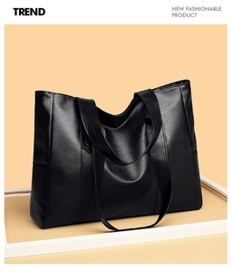 Close-up of black PU leather tote bag showing soft lychee texture and dual shoulder straps