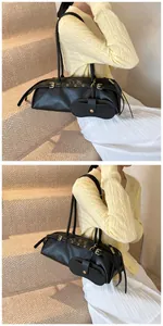 Detail of black baguette bag with decorative belt buckle and detachable coin purse