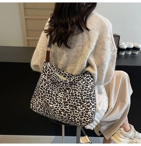 Detail of large leopard print tote bag with geometric strap and leather buckle detail