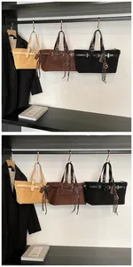 Close-up of matte tote bags with metal buckles and checkerboard ribbon charms