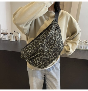 Detail of green leopard print chest bag with wide nylon strap in a cafe setting