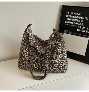 Detail of the leopard print tote bag with dual straps and premium golden metal buckles