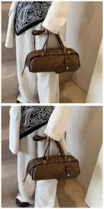 Detail of dark brown baguette bag with metal buckles and detachable crescent pouch