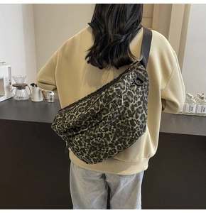 Detail shot of leopard print crossbody bag with adjustable strap on a female model