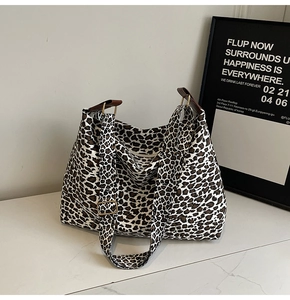 Close-up of leopard print canvas tote bag with adjustable strap and gold metal buckle