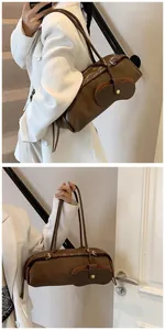 Detail of dark brown baguette bag with unique glasses pocket and slim shoulder straps