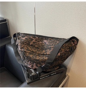 Close-up of leopard print crossbody bag with durable nylon strap and large buckle