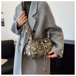 Détail du sac nuage plissé métallisé avec cordon de serrage sur un manteau
