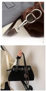 Detail show of silver metal hook and matte suede tote bag with leather strap