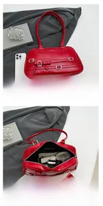 Detail showing red PU leather underarm bag with belt buckle and internal storage capacity