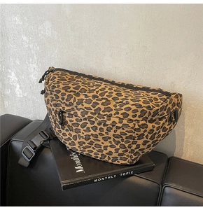 Detail of leopard print chest bag on a magazine showing canvas texture and adjustable strap