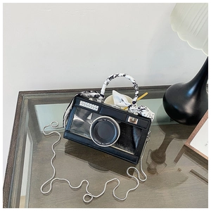 Macro shot of camera-shaped bag with rhinestone accents and floral scarf handle detail