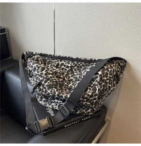 Detailed view of large leopard print crossbody bag with black adjustable wide strap