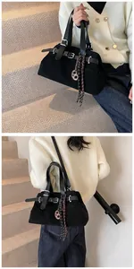 Detail of matte black tote bag with silver buckle and brown pretzel charm decoration