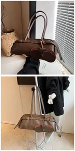 Detail of dark brown Boston bag with metal buckle straps and matching eyewear case pouch