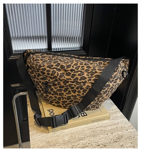 Detail of leopard print crossbody bag with adjustable wide strap and buckle closure