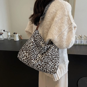Chic leopard print large tote bag with brown shoulder strap shown on a model