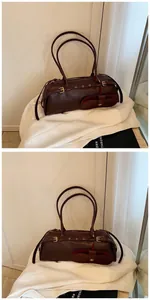 Macro detail of dark brown leather baguette bag with strap buckle and small pouch