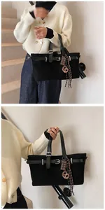 Detail of matte black tote bag with silver buckle and chocolate-shaped charm accessories