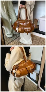 Detail of brown patent leather bowling bag with vintage pockets and baseball charm