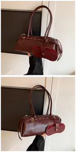 Macro detail of wine red faux leather bag with golden hardware and matching accessory bag