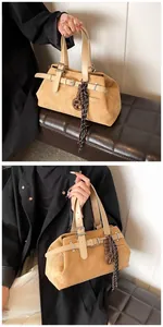 Detail of vintage ginger suede tote bag with leather straps and decorative charms