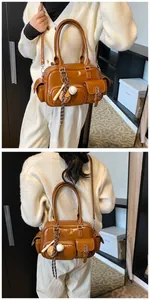 Detailed view of brown PU leather bowling bag with multiple pockets and baseball charm