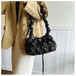 Détail du sac nuage noir matelassé avec bandoulière scrunchie et texture plissée