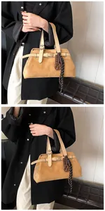 Close-up of vintage camel tote bag with matte finish metal buckle and decorative silk scarf