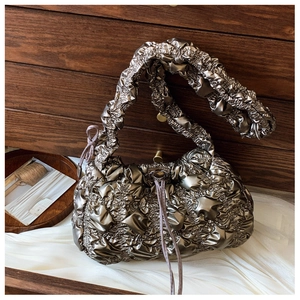 Détail du sac nuage plissé métallisé avec texture bronze et bandoulière souple froncée