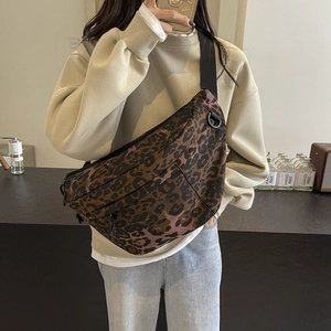 Leopard print crossbody waist bag with adjustable nylon strap shown in a cozy cafe setting